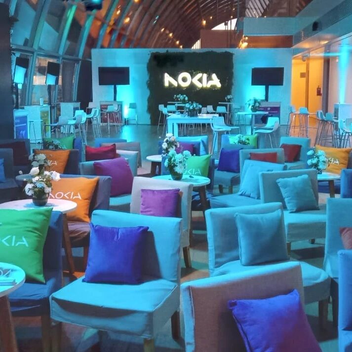 Evento Nokia con iluminación ambiental teal y lounge corporativo premium